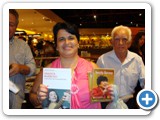 Sandra Cristina Peripato exibindo o livro e o DVD de Inezita Barroso